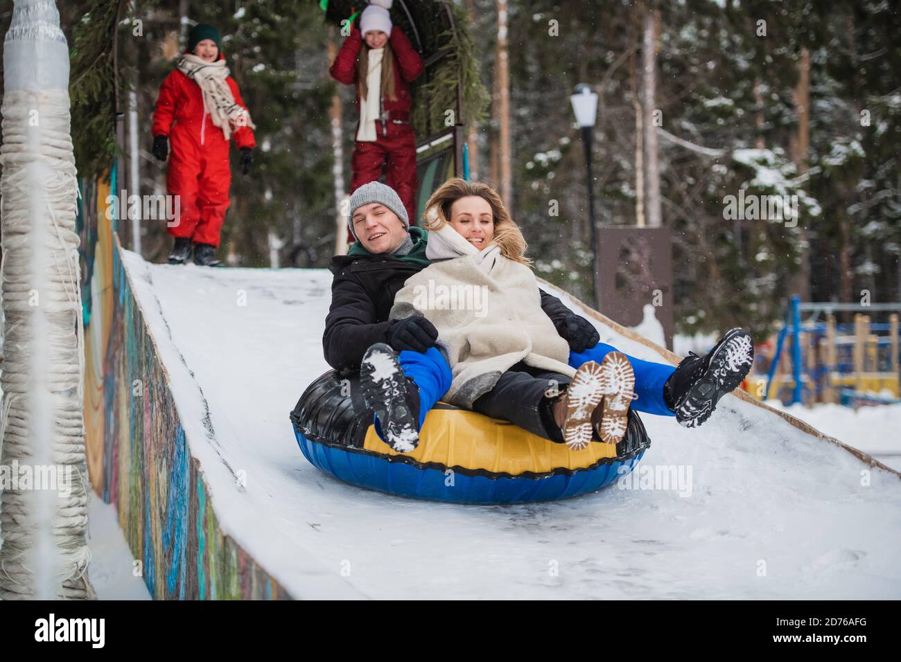 Winter entertainment for the whole family - roller coaster ride, mom, dad,  daughter, son are happy and enjoy spending time together Stock Photo - Alamy