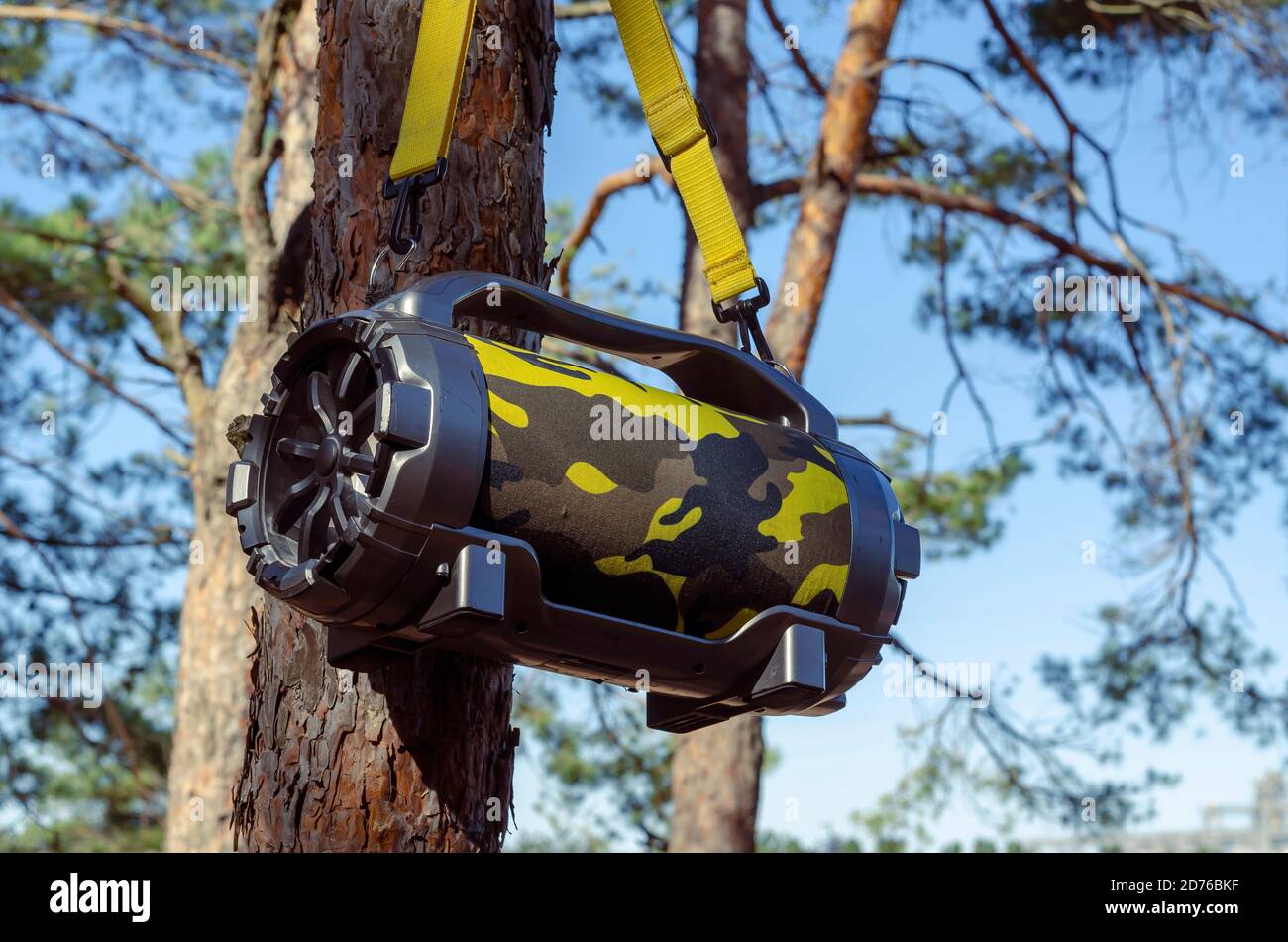Outdoor Portable Wireless Bluetooth Speaker With Subwoofer Big hanging on  tree in the forest. Acoustic portable speaker camouflage color with yellow  c Stock Photo - Alamy