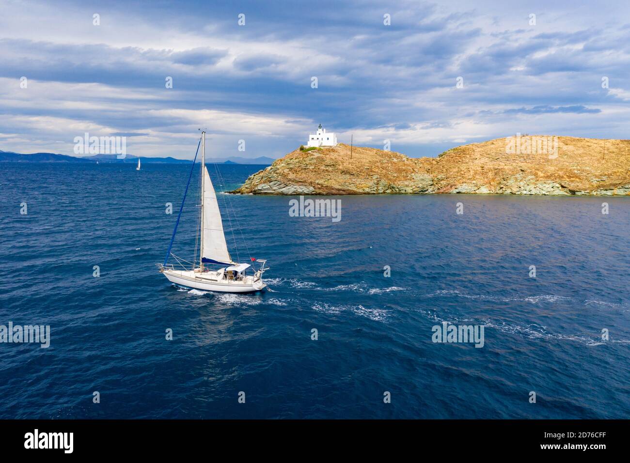 Sailing. Sailboat with white sails, rippled sea and cloudy sky