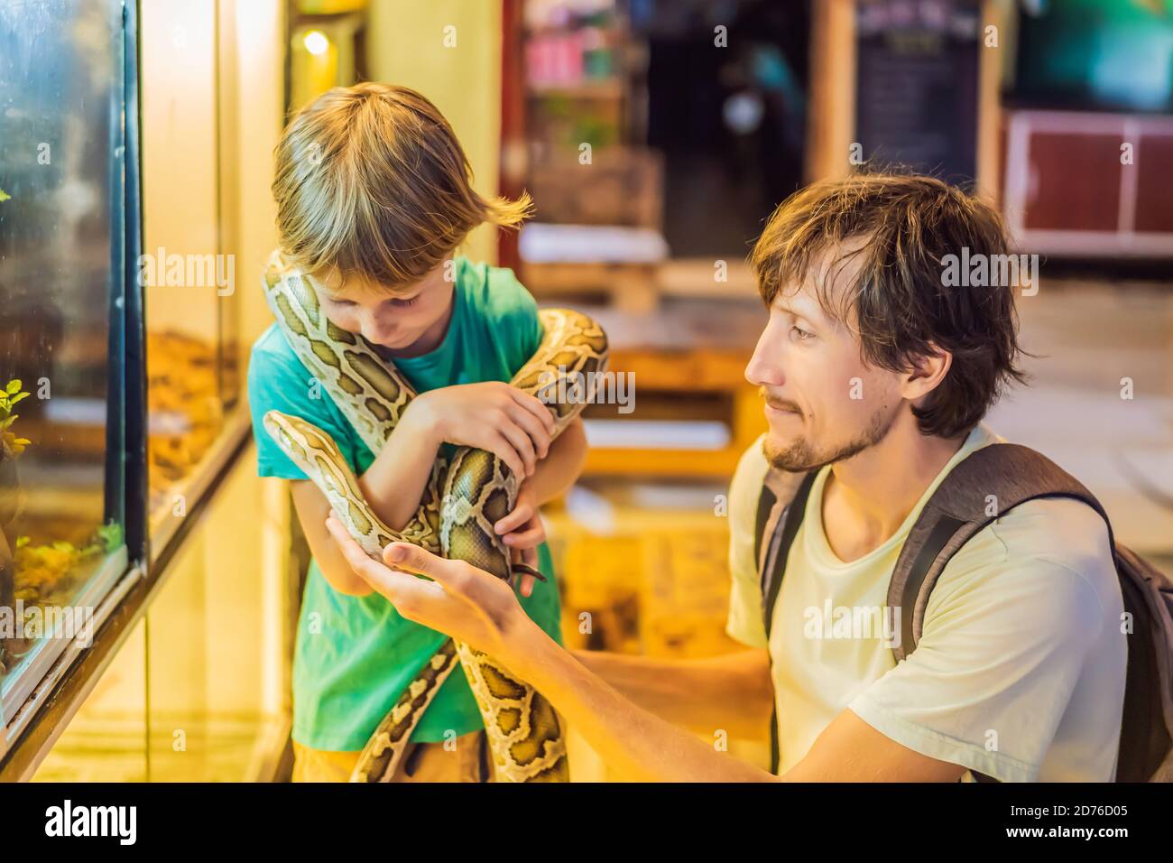 Smiling boy and his father holding python in hands Stock Photo - Alamy