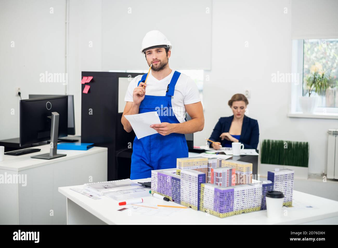 Young construction supervisor taking notes in the office. Stock Photo