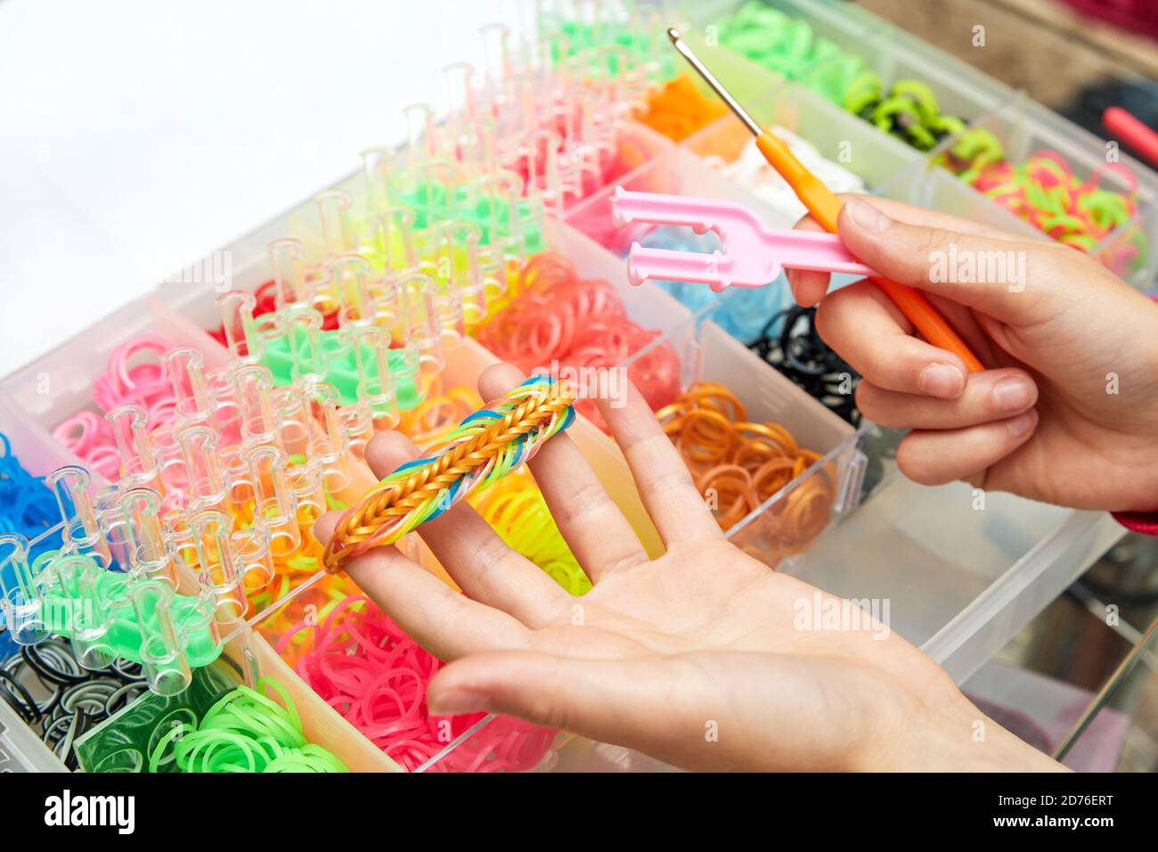 Rubber Band Weaving. Knitting rubber bands with loom knit. Hands of