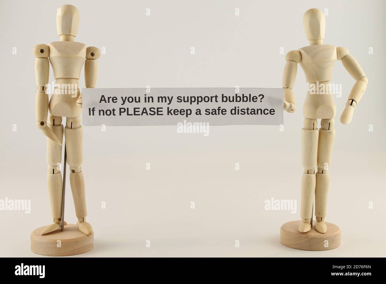 Are you in my support bubble, if not please keep a safe distance sign held by two manikins Stock Photo