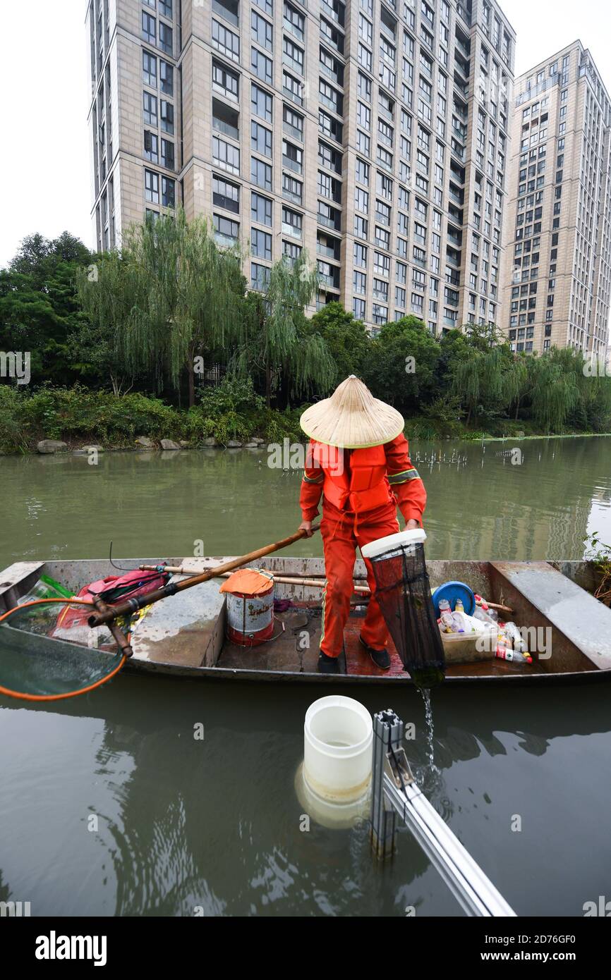 201021) -- HANGZHOU, Oct. 21, 2020 (Xinhua) -- A sanitation worker collects  wastes from an automatic cleaning machine in a river in Hangzhou, east  China's Zhejiang Province, Oct. 21, 2020. A series