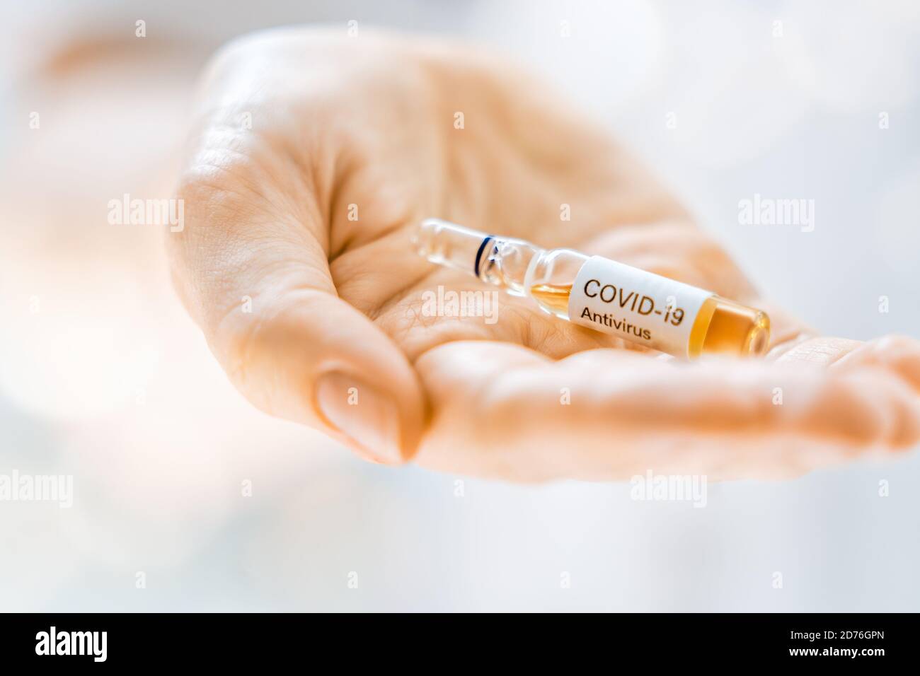 Medical doctor or laborant holding tube with anti Coronavirus vaccine. Concept of Covid-19 treatment and prevention. Stock Photo