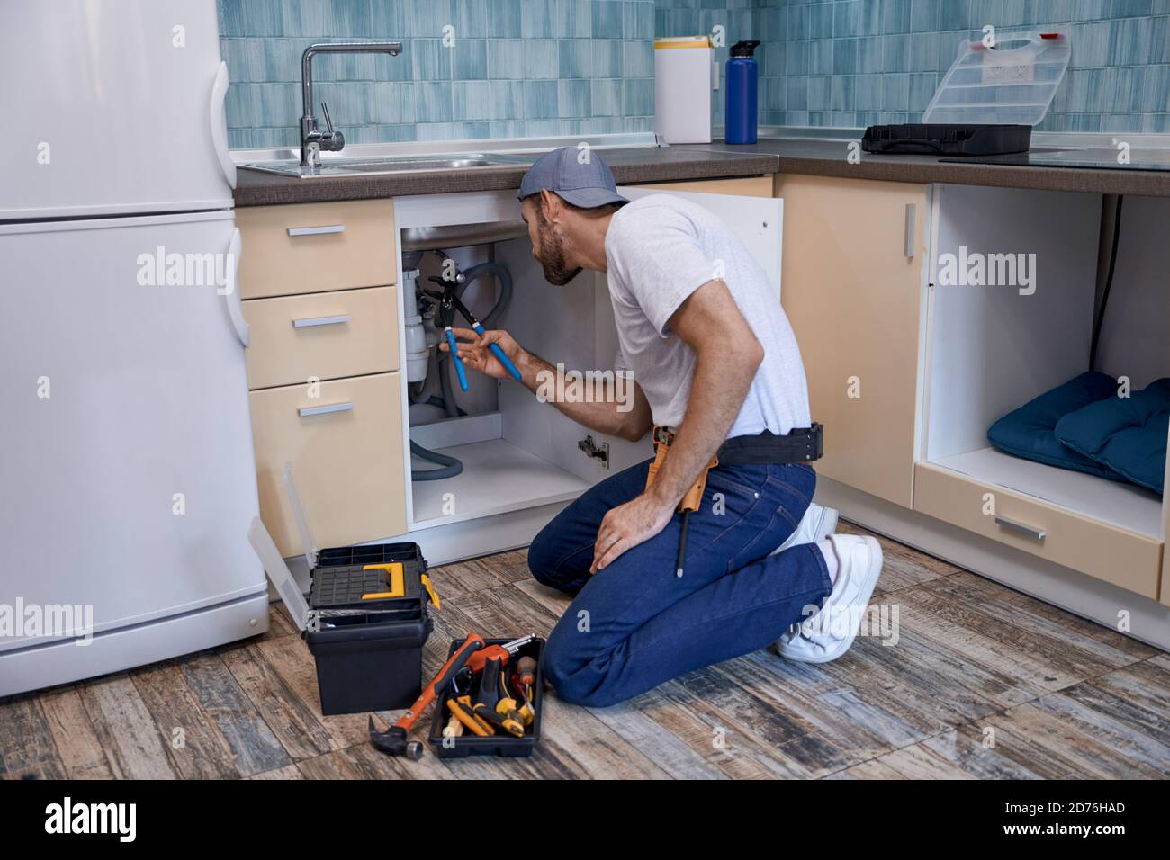 Side View Of A Male Plumber Using Plunger In Kitchen Sink Stock Photo -  Alamy