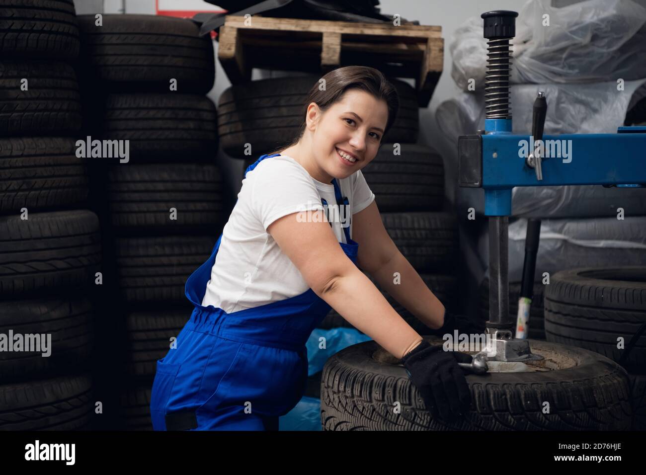 Happy workwoman is using a press and looking at the camera Stock Photo