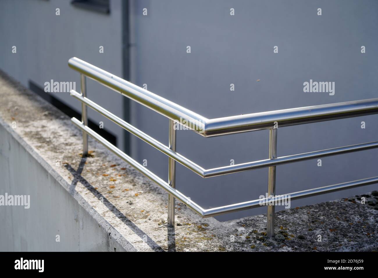 Modern stainless steel railing mounted on a concrete wall Stock ...