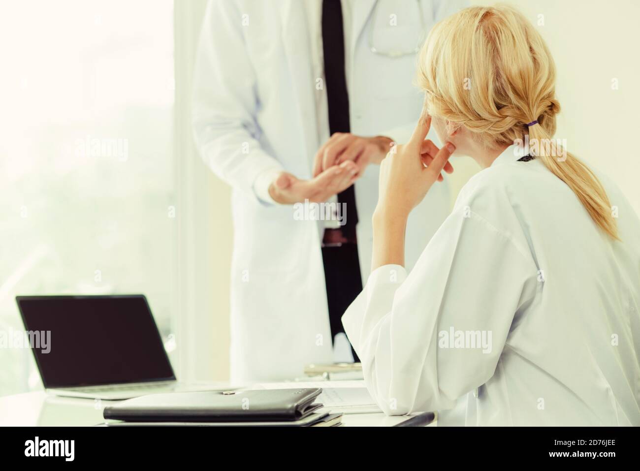 Young female doctor at hospital office having conversation talking with ...