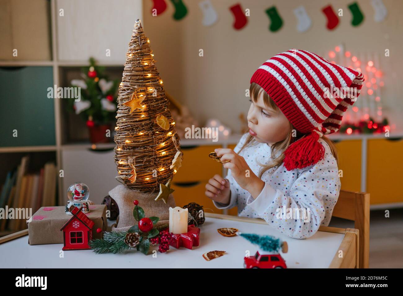 Little girl decorated Christmas eco tree indoor Stock Photo