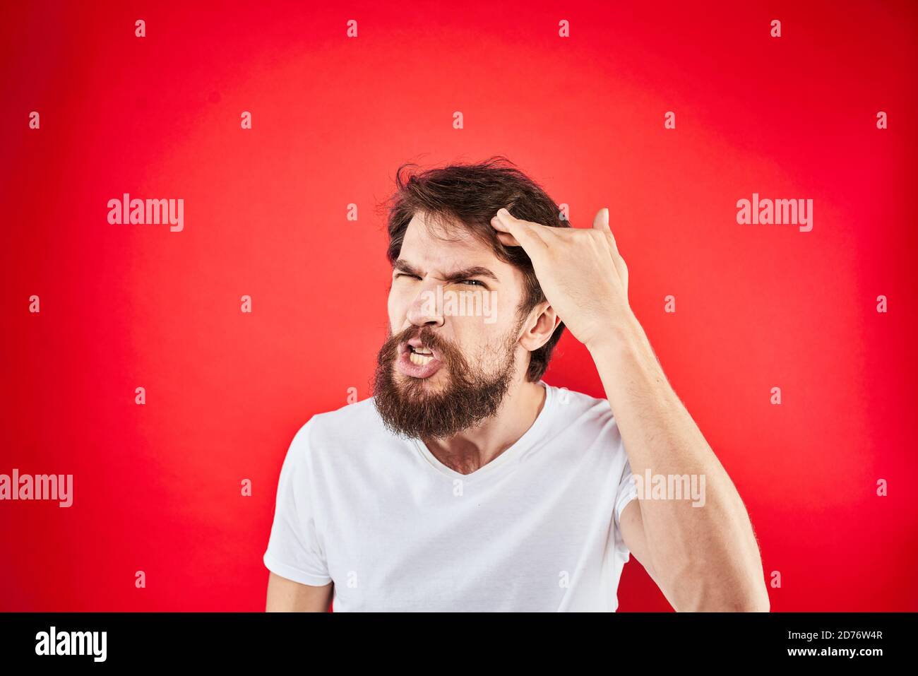 Emotional bearded man gestures with his hands in a white T-shirt ...