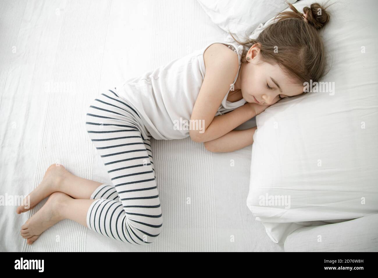 sleeping girl child A cute little girl is sleeping in a white bed . Concept of child  development and sleep. The view from the top Stock Photo - Alamy