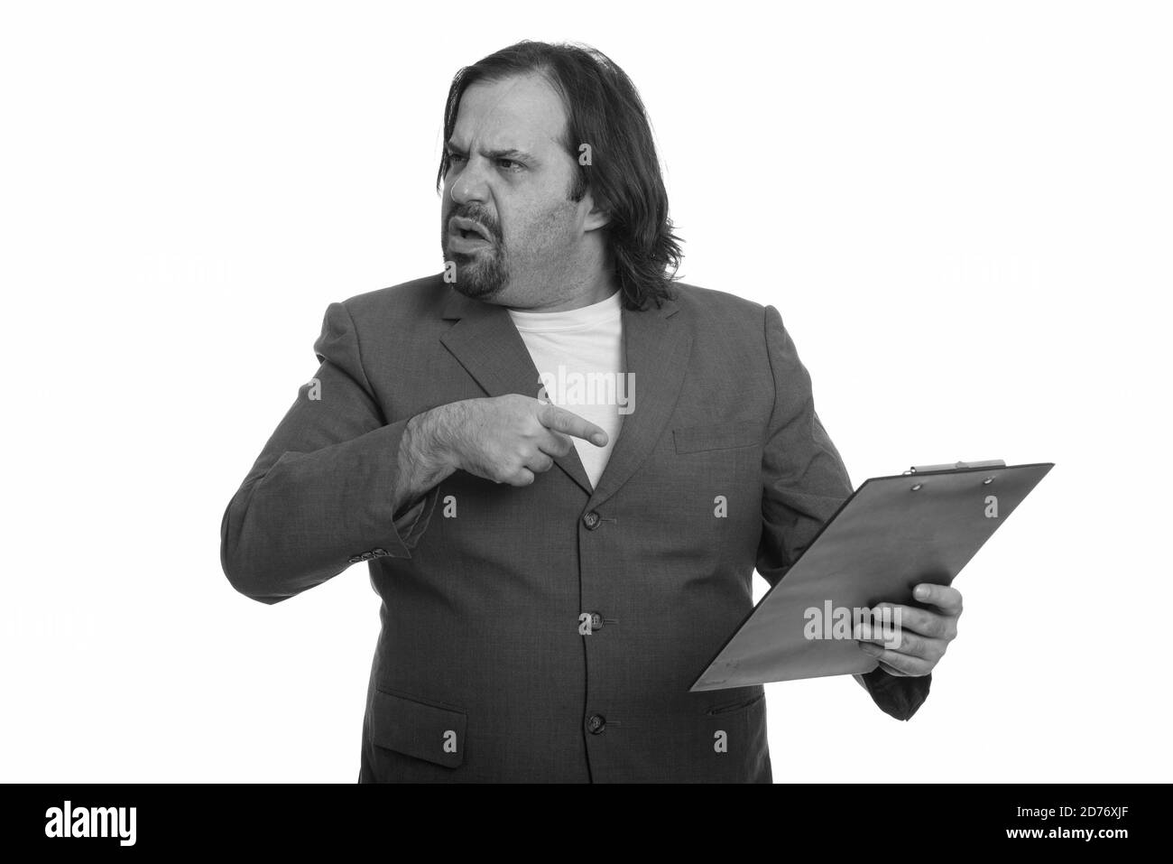 Fat Caucasian businessman looking angry pointing and holding clipboard Stock Photo