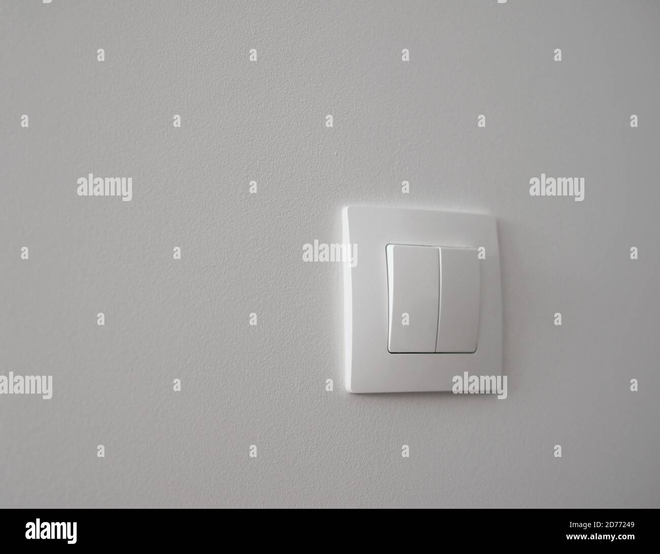 White light switch on a white wall Stock Photo
