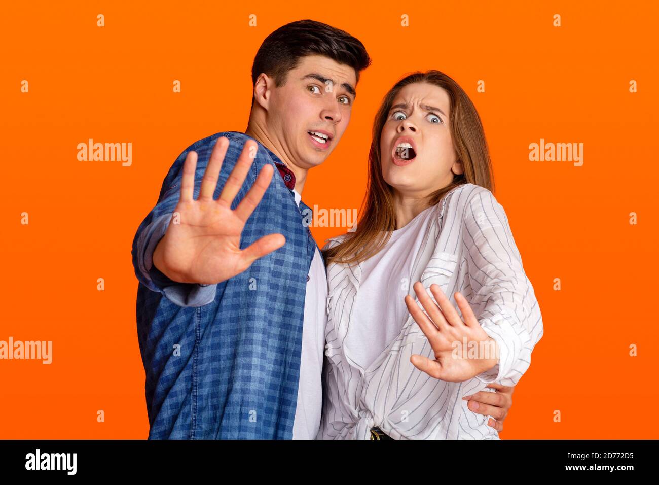 Shock, disgust and horror. Frightened young man and lady nervous fenced off with hands Stock Photo