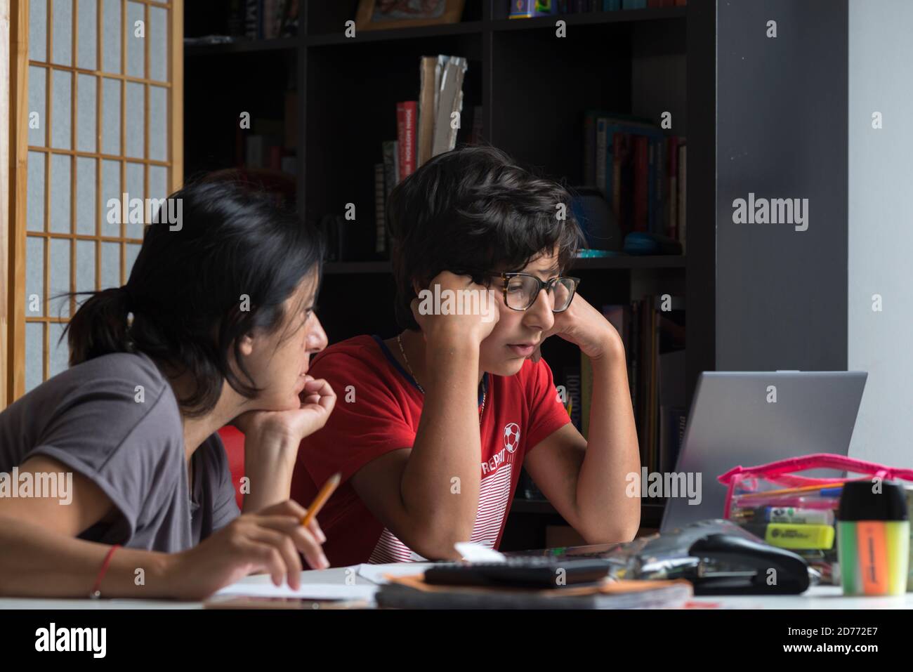 Remote learning during lockdown- mother helps pupil with home studies,Surrey,UK Stock Photo