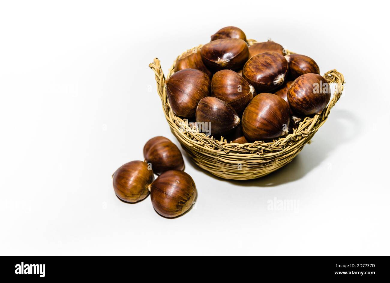 Chestnuts in wicker basket on white background Stock Photo