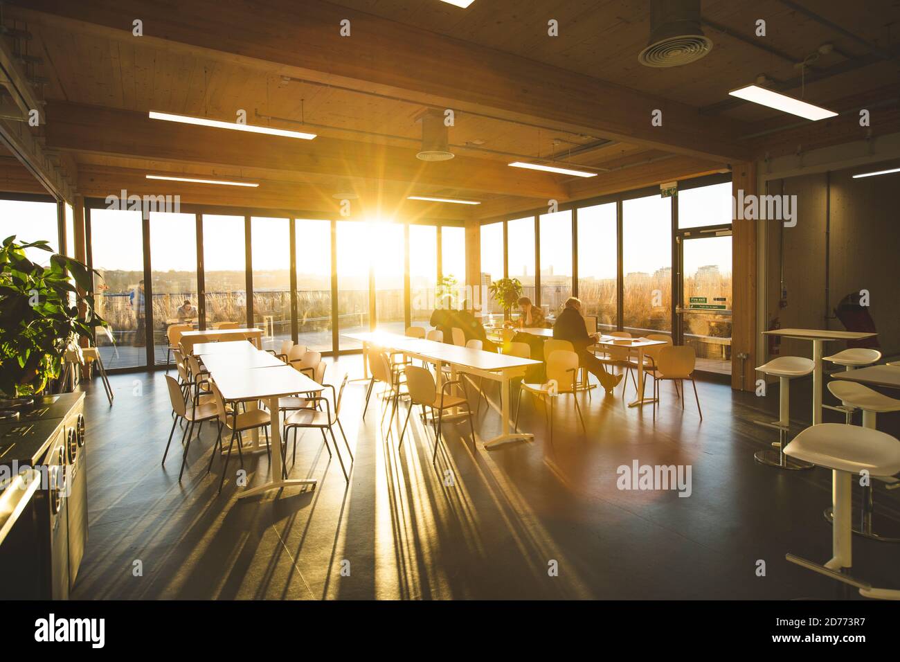 London, UK, January 19, 2020: People working at coworking space area roof top with sunset Stock Photo