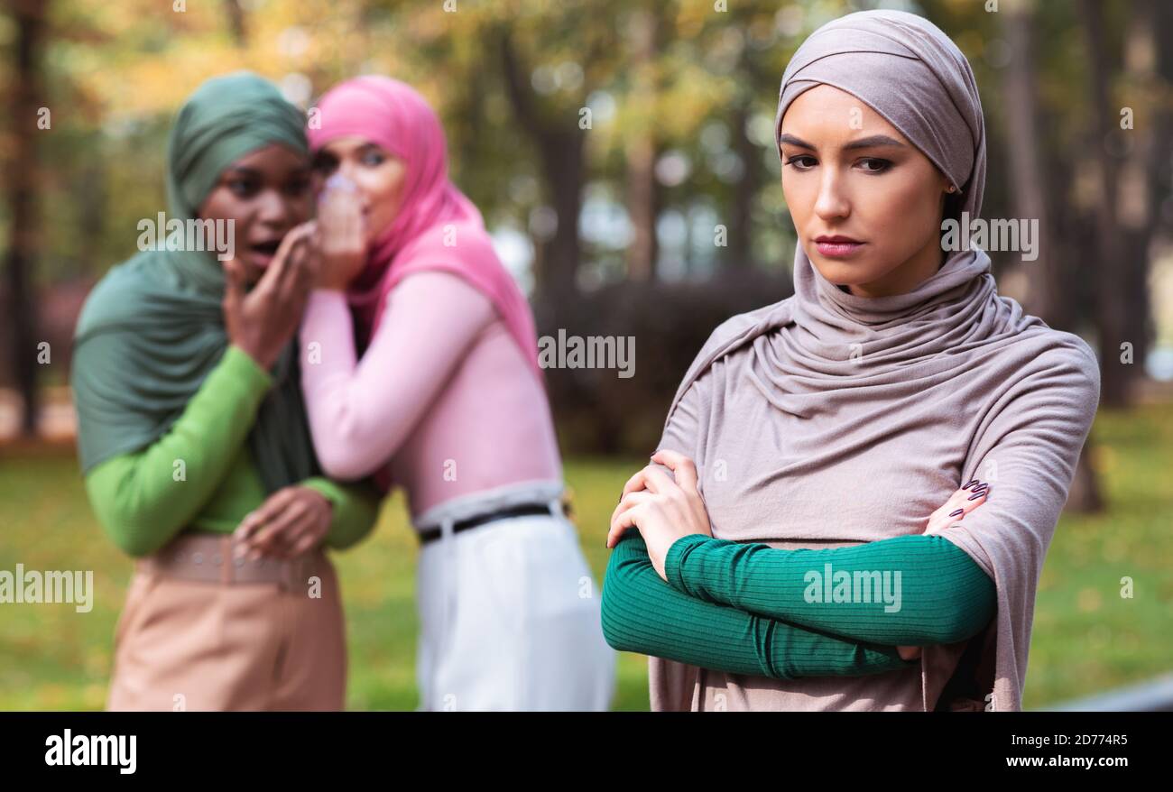 Bad Friends Talking About Unhappy Muslim Woman Standing Alone Outdoor Stock Photo