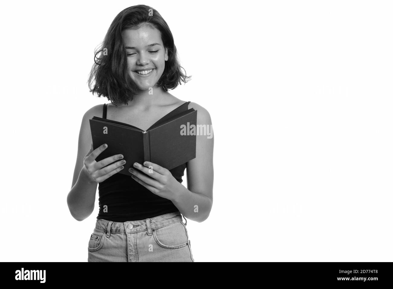 Young happy Caucasian teenage girl smiling and reading book Stock Photo ...