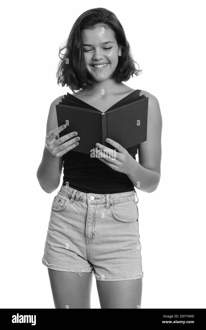 Young happy Caucasian teenage girl smiling and reading book Stock Photo ...