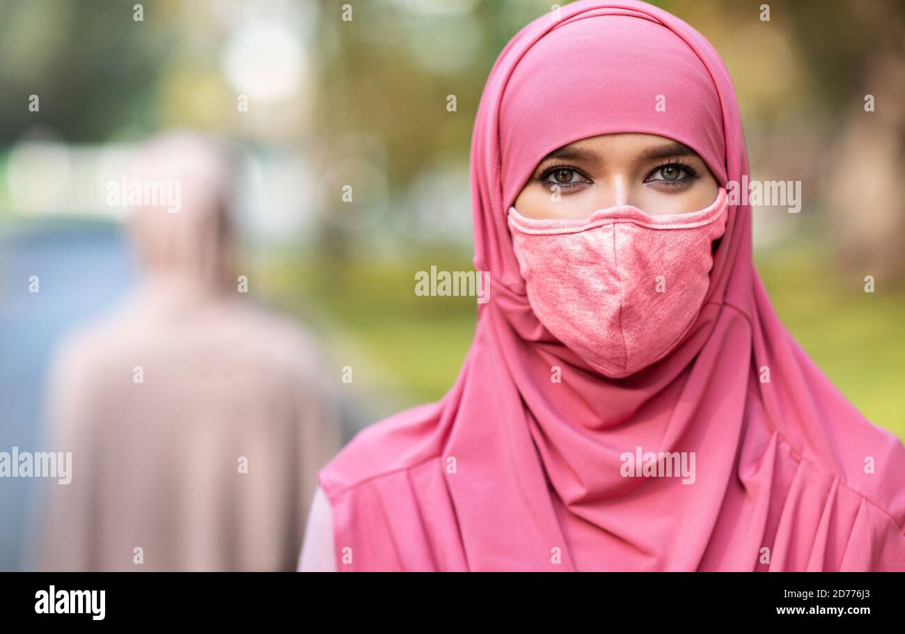 Arab Woman In Protective Face Mask Posing Outdoors Stock Photo