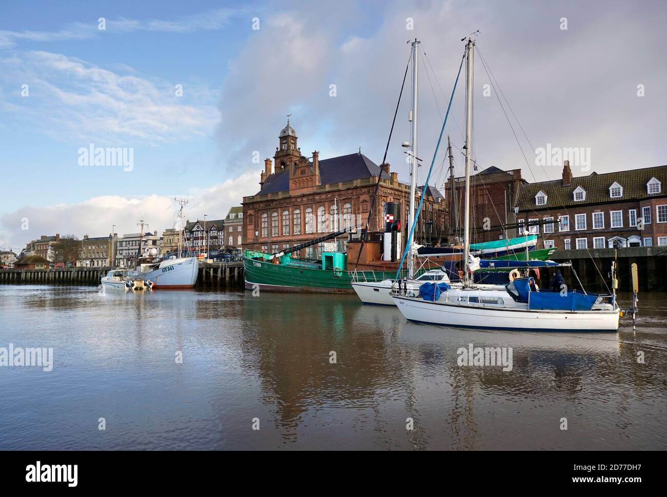 pair of sailing boats motoring  past great yarmouth town hall on river yare norfolk england Stock Photo