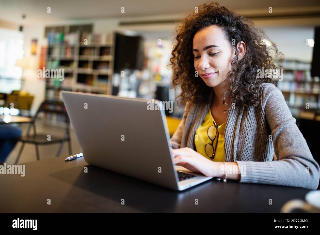 Portrait of happy student woman working on laptop Stock Photo