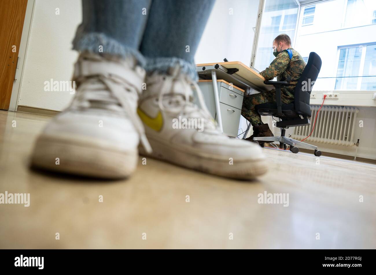 Stuttgart, Germany. 21st Oct, 2020. A soldier of the Jägerbataillon 292 from Donaueschingen supports the public health department in a building of the city of Stuttgart in corona contact tracing, in the foreground is a journalist in sneakers. The public health authorities in Baden-Württemberg are increasingly looking for personnel to track infection chains. In the state capital, 60 soldiers of the Hunter Battalion are deployed. Credit: Marijan Murat/dpa/Alamy Live News Stock Photo