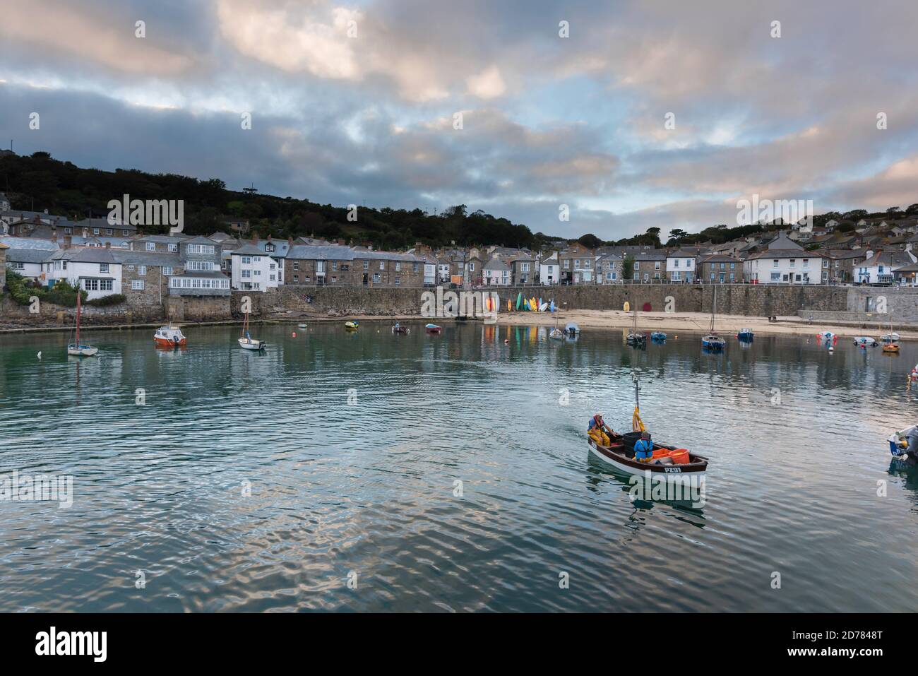 Mousehole Cornwall, view at dusk of a fishing boat leaving Mousehole harbour, Cornwall, south west England, UK Stock Photo