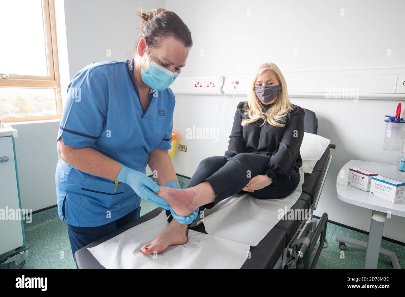 Lee-Anne Jones, from Foulden, Berwickshire, has the burn wound on her foot checked by nurse Isabelle Sweeny at the burns unit at St John's Hospital, Livingston. Lee-Anne received a new treatment called NexoBrid that uses enzymes extracted from pineapple plants to help remove the dead or burnt skin, leaving behind only healthy tissue. Stock Photo