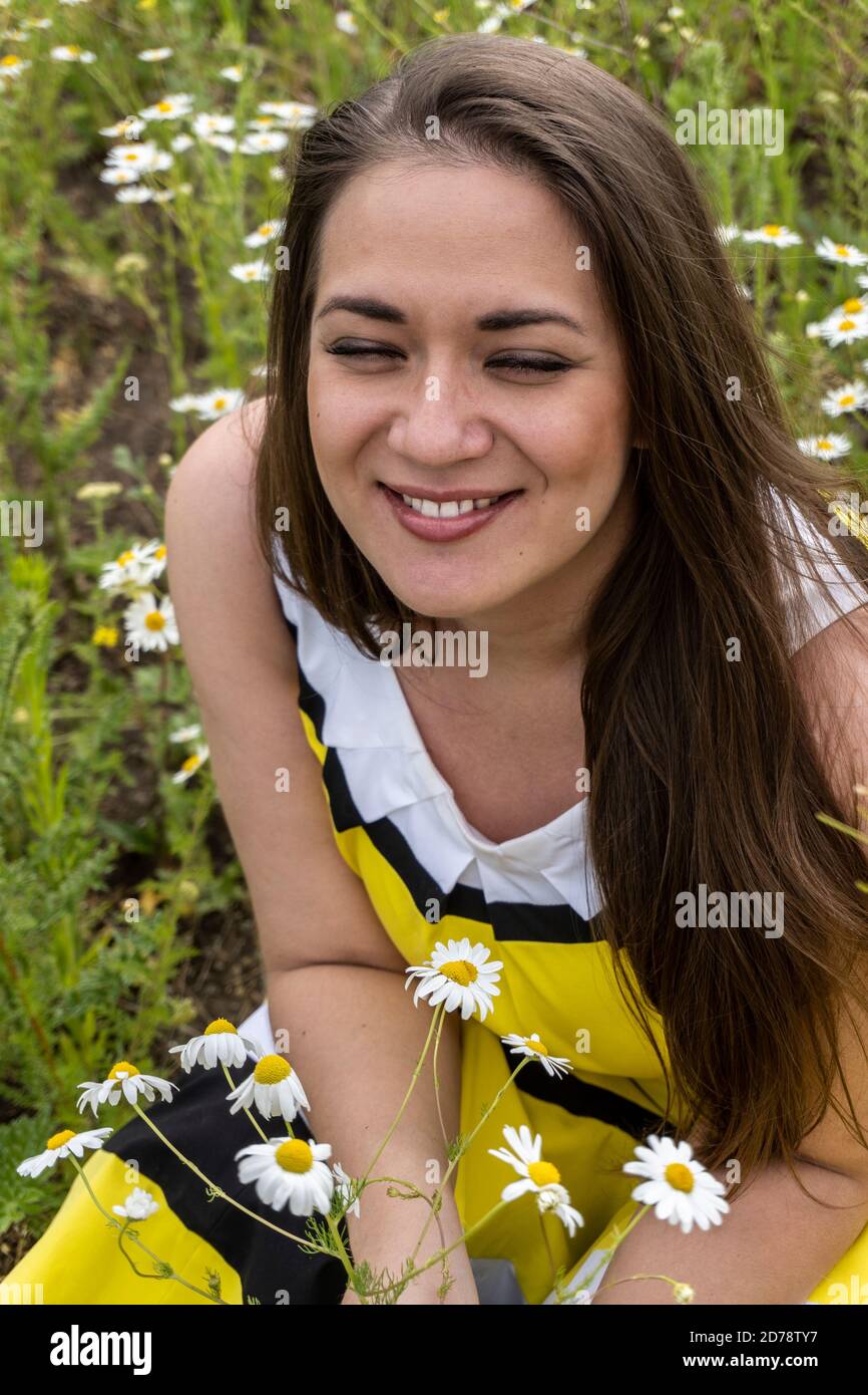Portrait of a young beautiful girl in a field with flowers, girl
