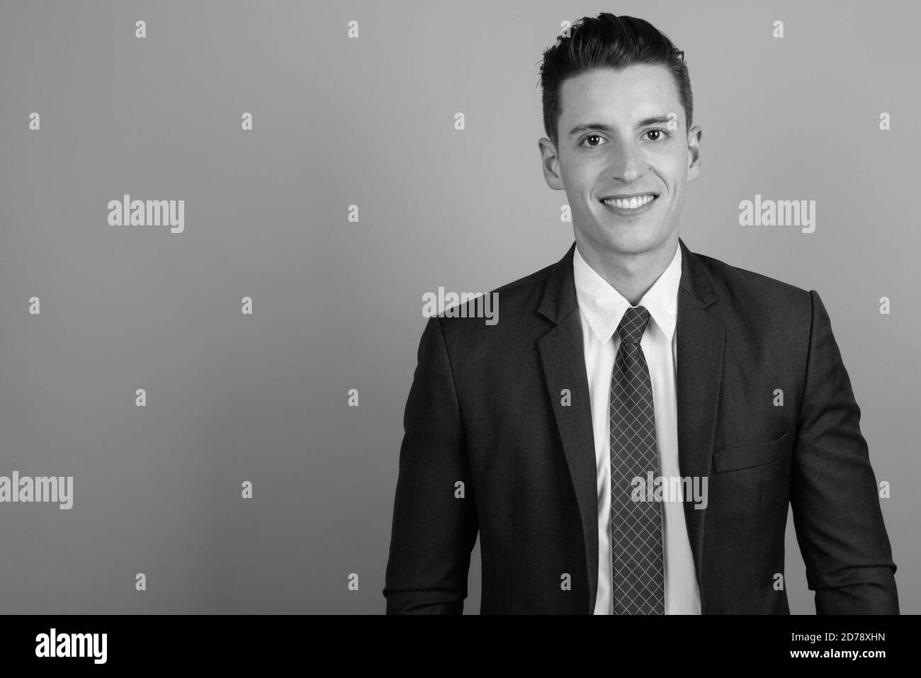 Young handsome businessman wearing suit against gray background Stock ...
