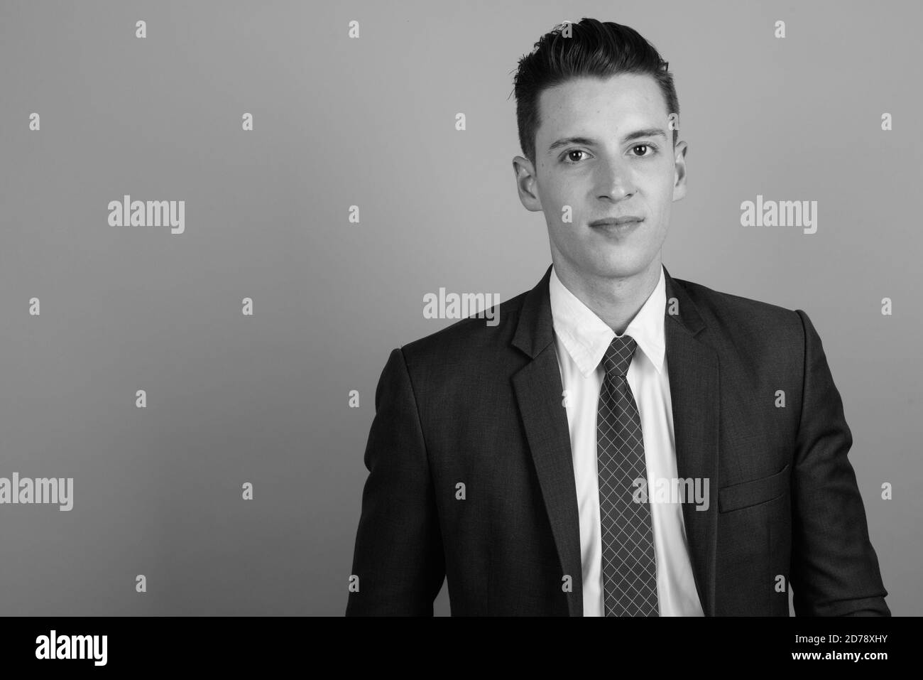 Young handsome businessman wearing suit against gray background Stock ...