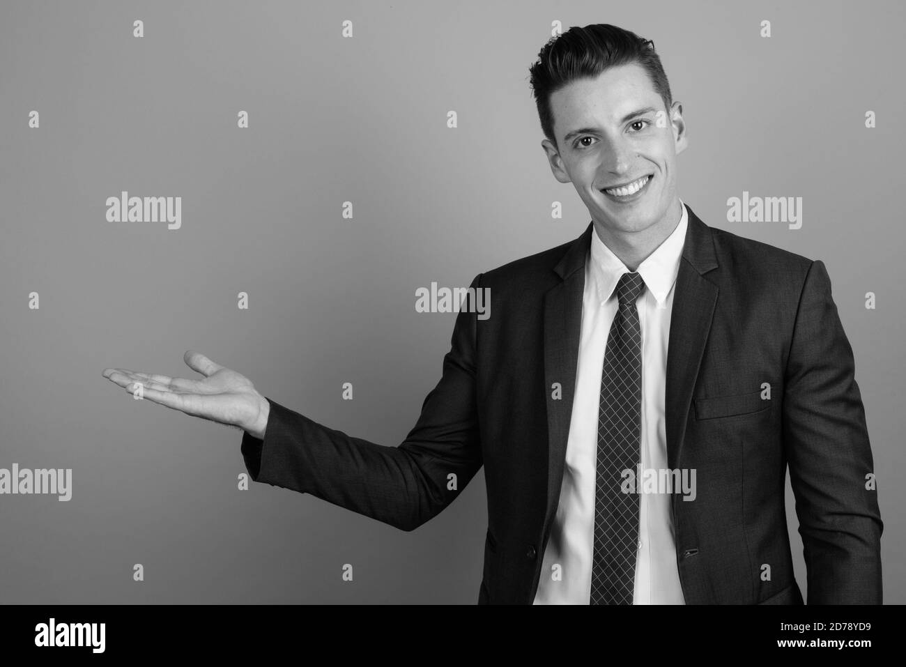 Young handsome businessman wearing suit against gray background Stock ...