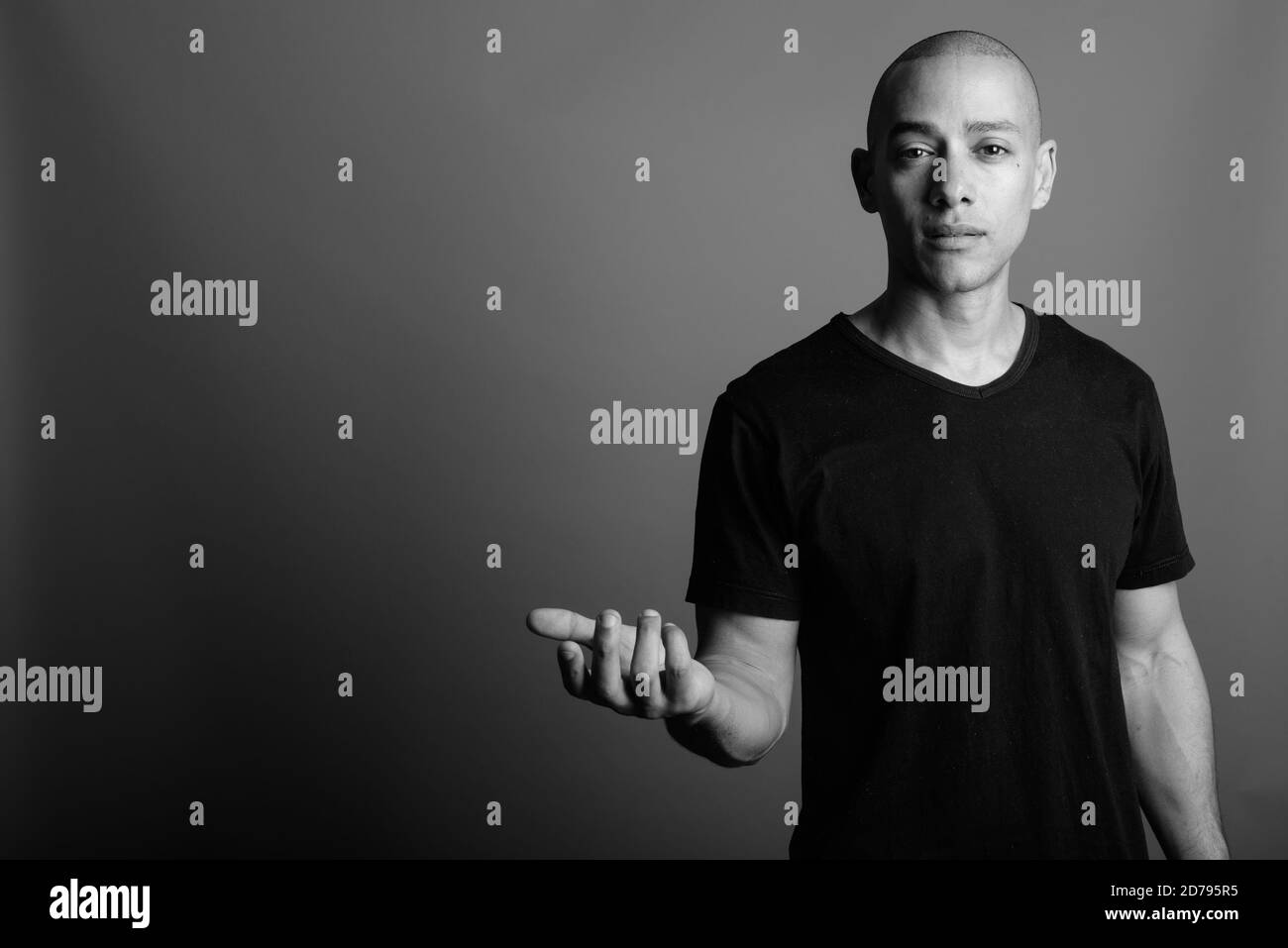 Handsome bald man wearing black shirt against gray background Stock Photo