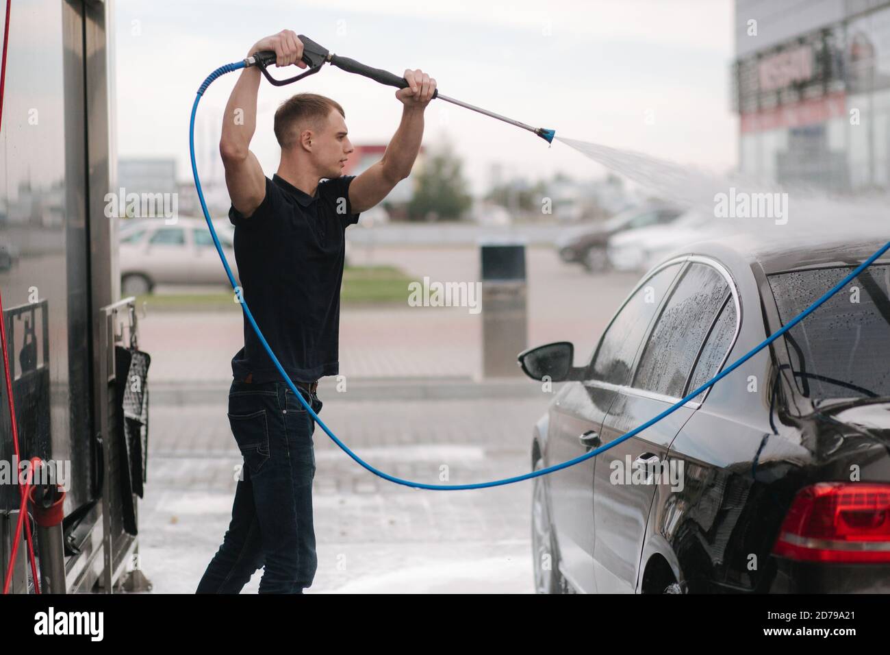 Worker cleaning car using high pressure water Stock Photo - Alamy