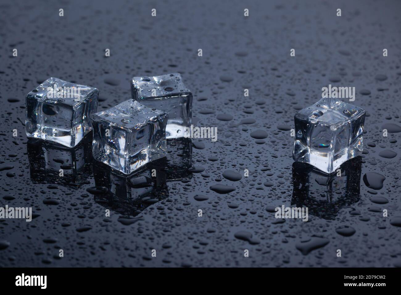 four ice cubes on black glass Stock Photo
