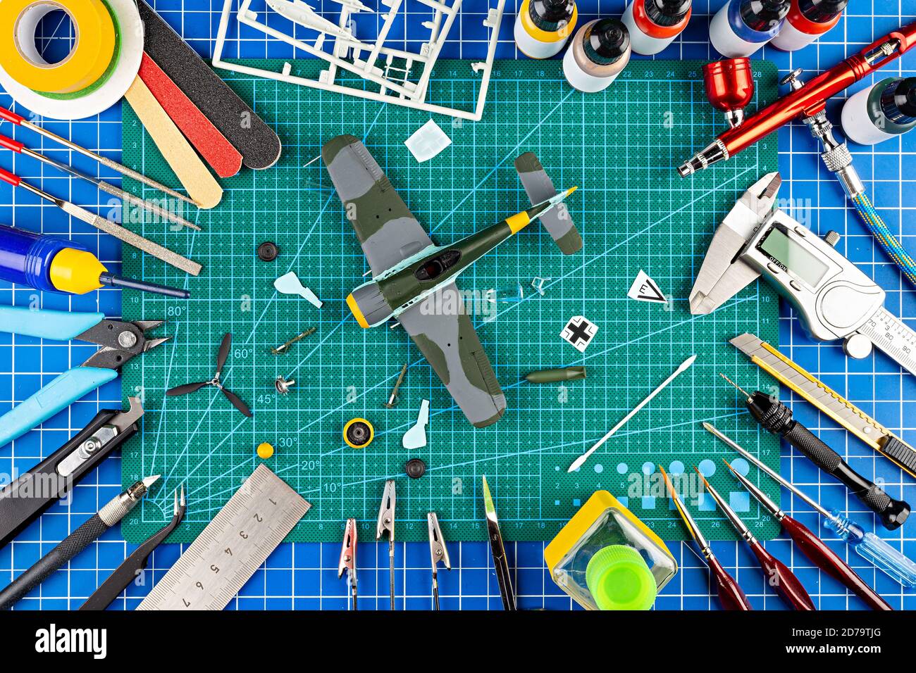desktop view from above of assembly and painting of retro scale model fighter plane concept background. modeling tools airbrush gun paint kit parts bl Stock Photo