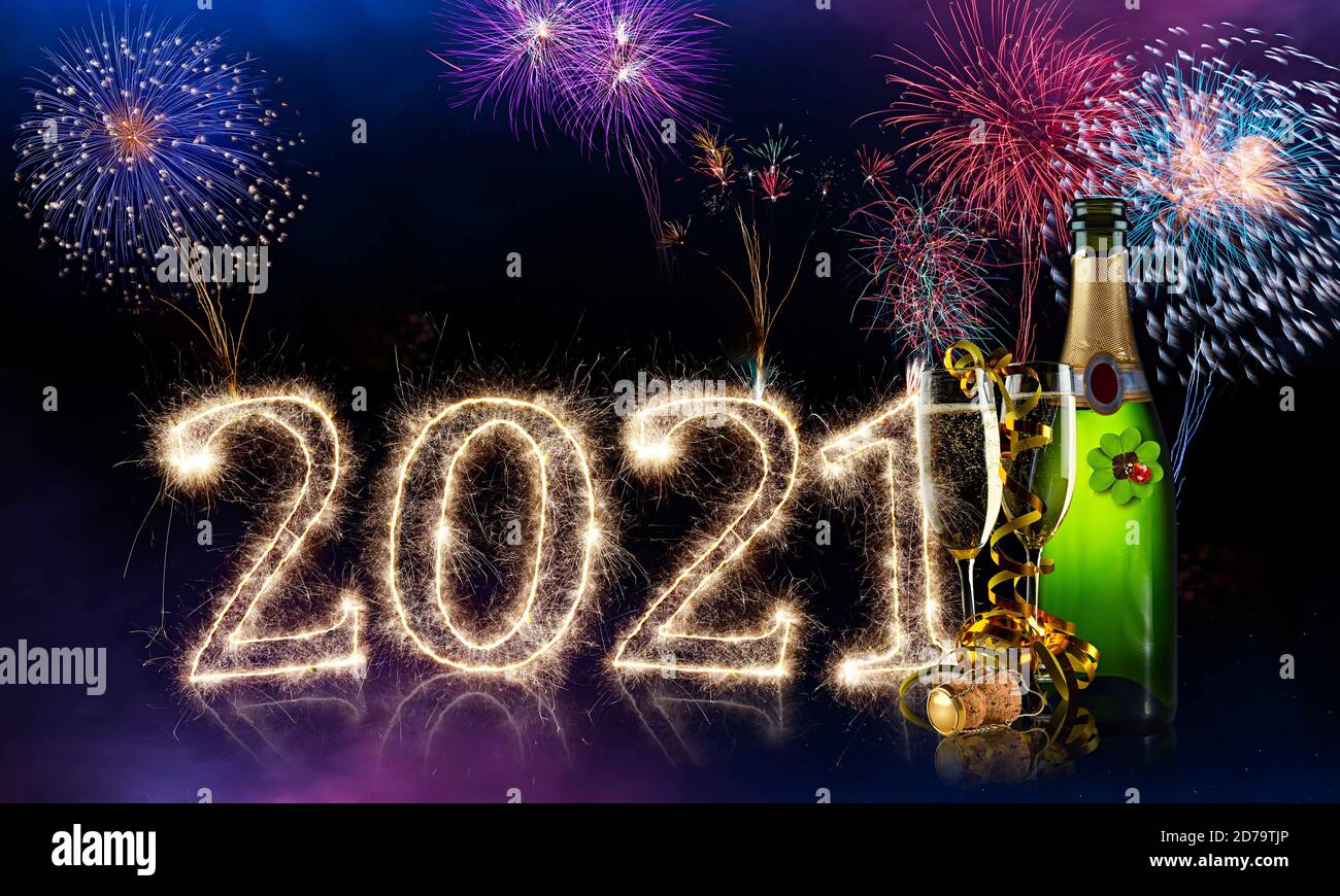happy new year eve colorful fireworks sparkler 2021 number four leaf clover champagne bottle glass in front of red purple blue black bokeh night panor Stock Photo