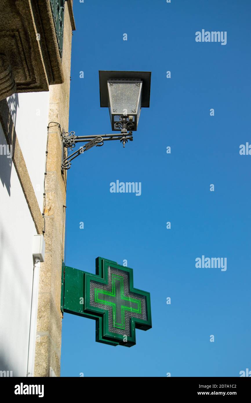 Looking at Pharmacy Green cross outdoor sign in the streets of Braga, Portugal Stock Photo