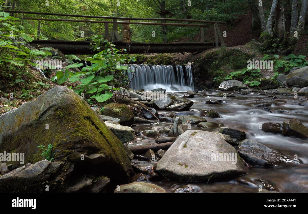 Flowing waterfall under wooden bridge Stock Photo
