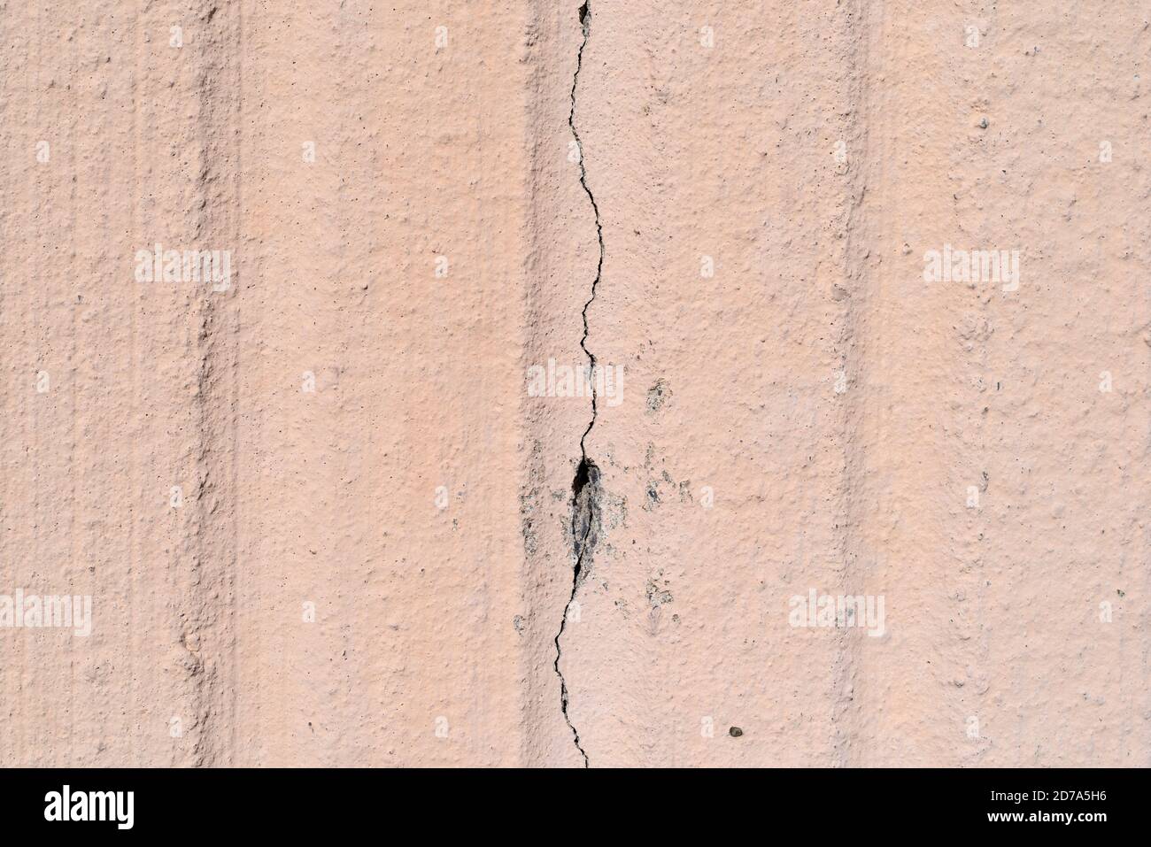 Close view of a poured exterior concrete wall with a large stress crack. Stock Photo