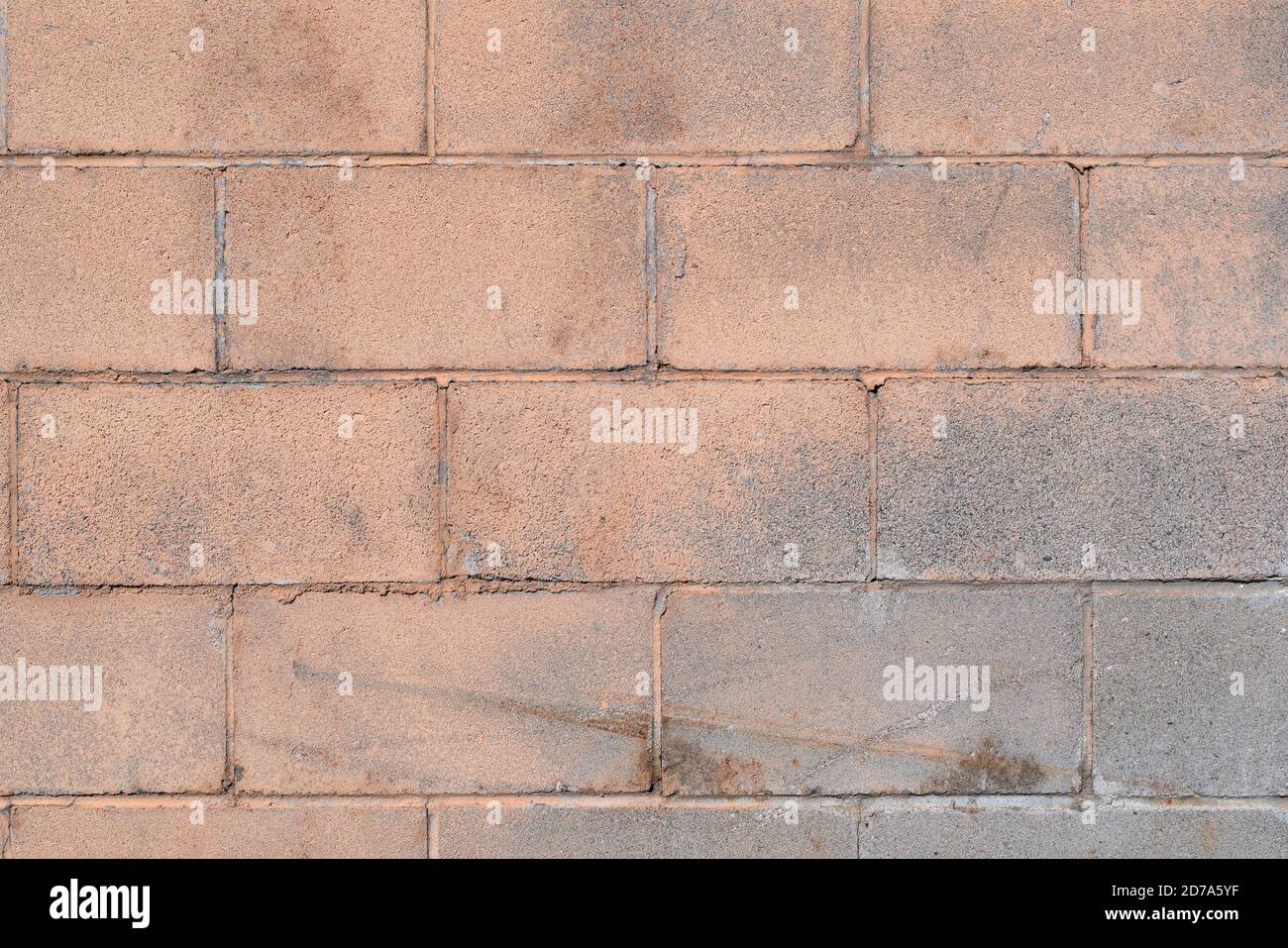 Very dirty masonry wall blocks with peeling beige paint and scratches from age in the early morning light. Stock Photo