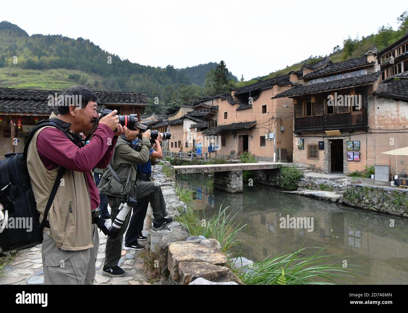 (201021) -- FUJIAN, Oct. 21, 2020 (Xinhua) -- People take photos in Longtan Village of Pingnan County in Ningde City, southeast China's Fujian Province, Oct. 21, 2020. Longtan Village had been a provincial-level poverty-stricken village due to lack of arable land. Villagers went out for work one after another with many old buildings left in disrepair. In 2017, the county government launched a project to boost ancient villages through cultural and creative industries. The old houses, once forgotten, have been connected to public utilities, reinforced and decorated inside, with the ancient appe Stock Photo