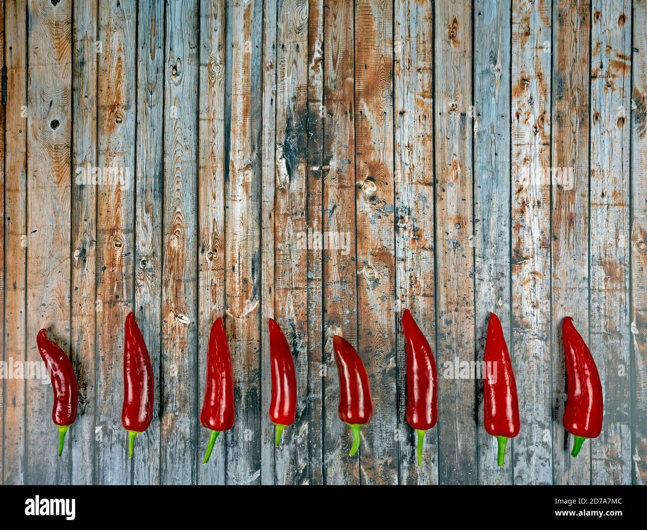 Design of dark wood background with chili peppers Stock Photo - Alamy