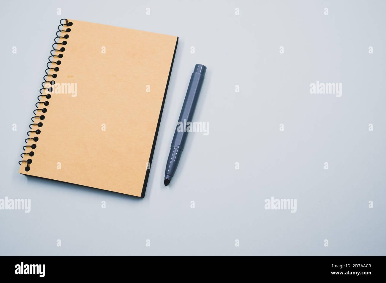 High angle shot of a notebook and a marker on a blue surface Stock Photo