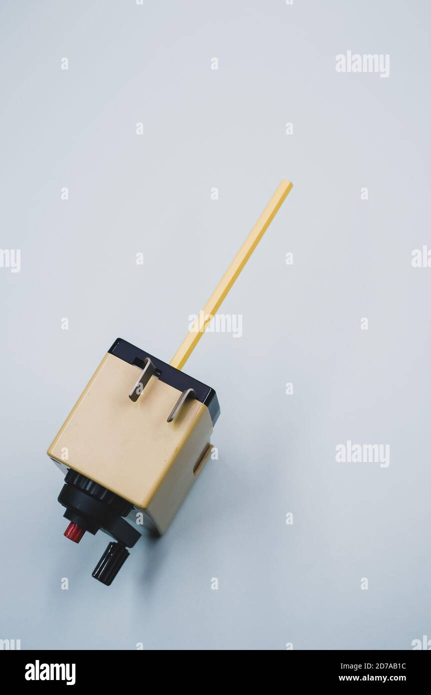 Vertical shot of a mechanical pencil sharpener on a blue surface Stock Photo