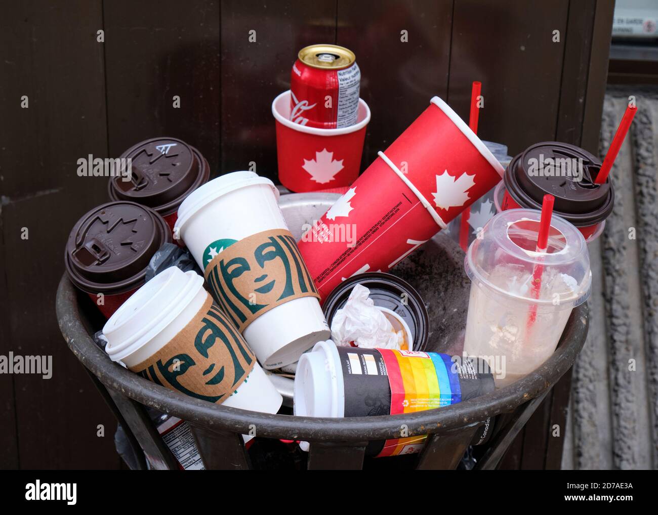 Outdoor garbage can filled with disposable single use cups from various coffee shops Stock Photo