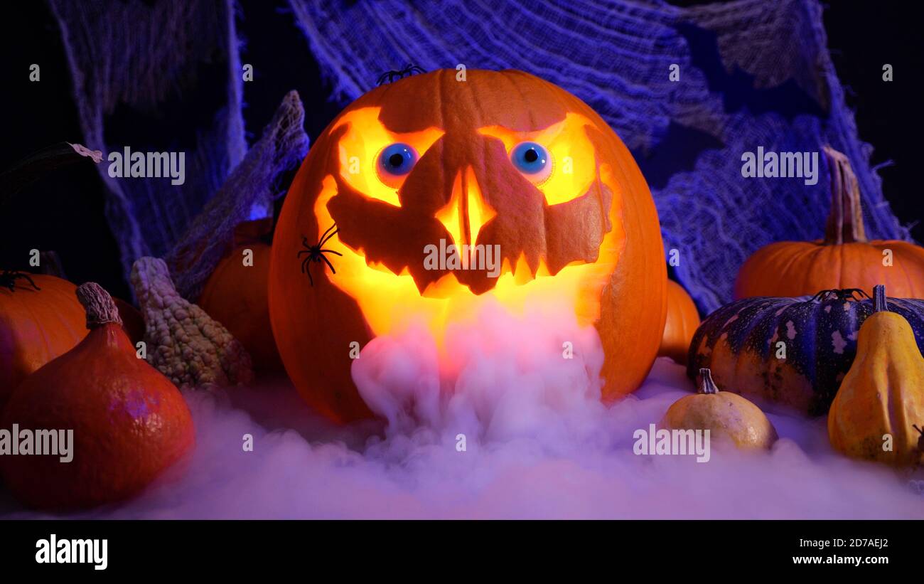 Halloween pumpkin Jack o lantern with smoke. Halloween pumpkins on spooky background, misty fog. October holidays concept. Perfect carved pumpkin Stock Photo